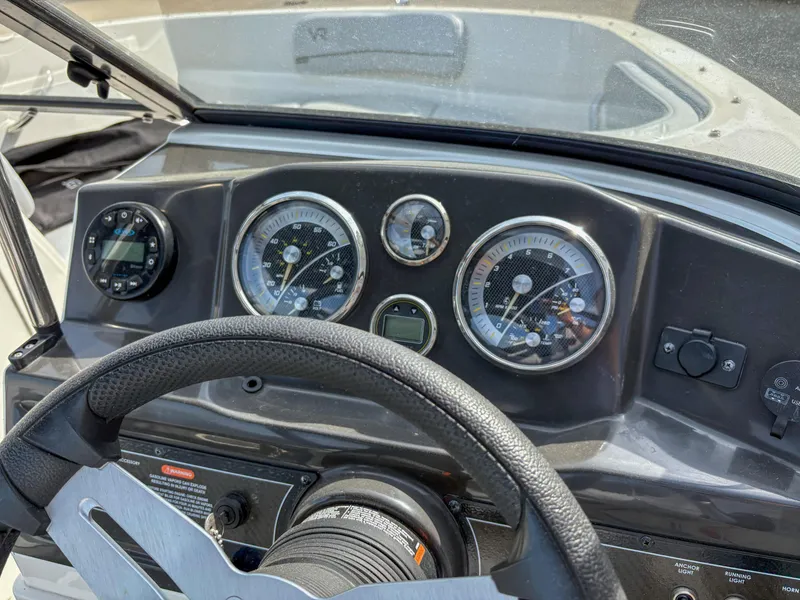 Slide: The Image of Dashboard of a 2021 Bayliner VR4 boat with steering wheel and gauges. - 13