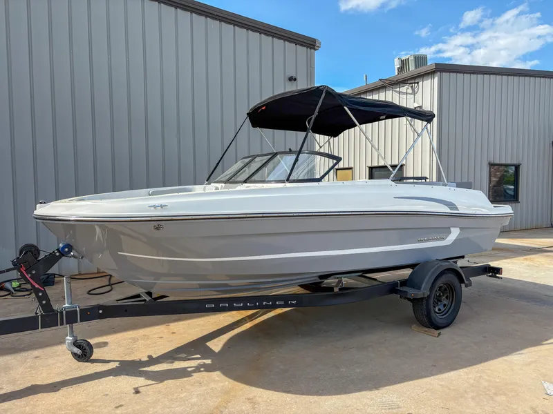 Slide: The Image of 2021 Bayliner VR4 boat on trailer, parked outside a building under a clear sky. - 4