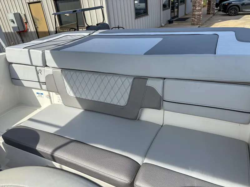 Slide: The Image of 2021 Bayliner VR4 boat interior with gray and white cushioned seating. - 9