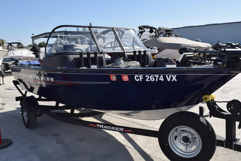 Slide: The Image of 2024 Tracker Pro Guide V-16 WT boat on trailer, parked outdoors. - 2
