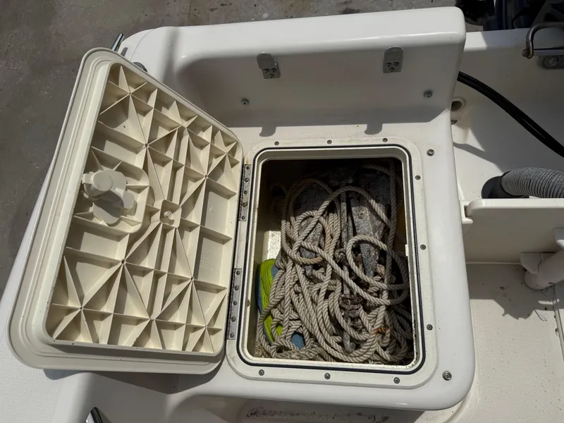 Slide: The Image of Open storage compartment on 2008 Cobia 194 Center Console boat with coiled rope inside. - 12