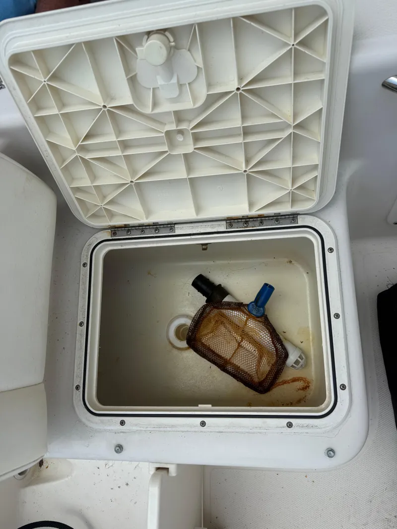 Slide: The Image of Open storage compartment on 2008 Cobia 194 Center Console boat with fishing gear inside. - 13