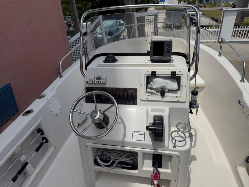 Slide: The Image of 2008 Cobia 194 Center Console boat interior with steering wheel and navigation equipment. - 15