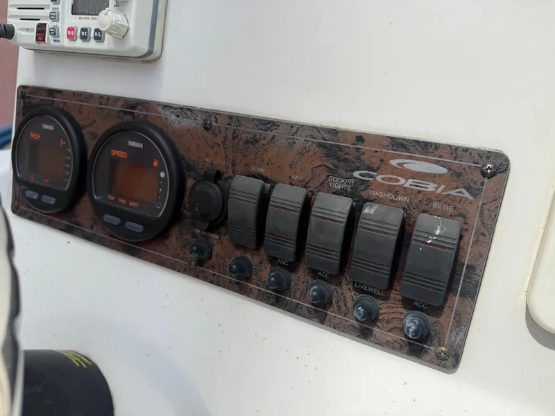 Slide: The Image of Control panel of a 2008 Cobia 194 Center Console boat with gauges and switches. - 21