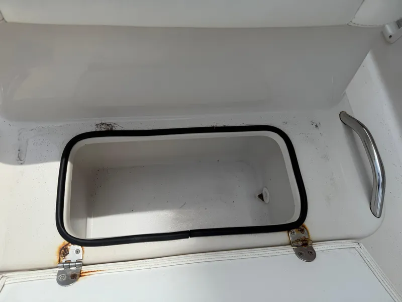 Slide: The Image of Storage compartment on a 2008 Cobia 194 Center Console boat, featuring a metal handle. - 24
