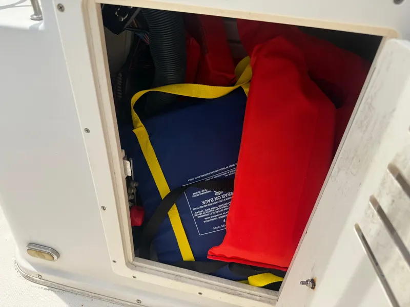 Slide: The Image of Storage compartment with life jackets on a 2008 Cobia 194 Center Console boat. - 25
