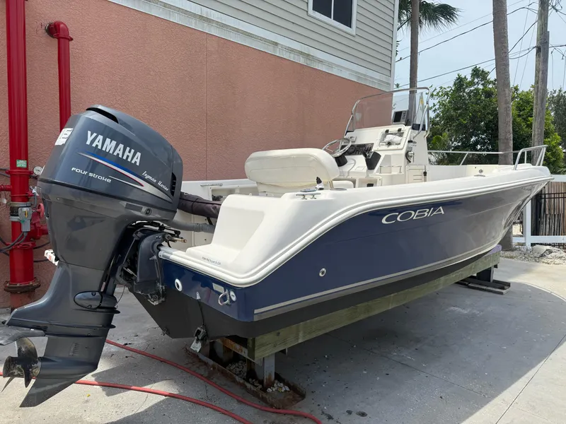 Slide: The Image of 2008 Cobia 194 Center Console boat with Yamaha outboard motor, parked outdoors. - 4