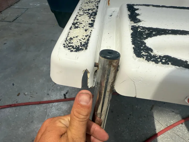 Slide: The Image of Close-up of a 2008 Cobia 194 Center Console boat with damaged corner and peeling paint. - 7