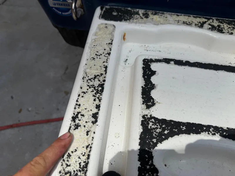 Slide: The Image of Close-up of a 2008 Cobia 194 Center Console boat with peeling paint. - 8