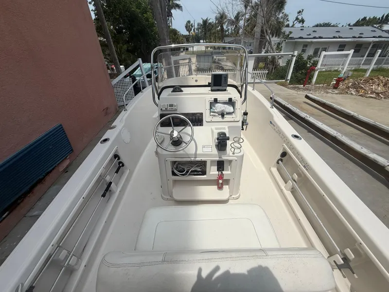 Slide: The Image of 2008 Cobia 194 Center Console boat with steering wheel and control panel, docked outdoors. - 9