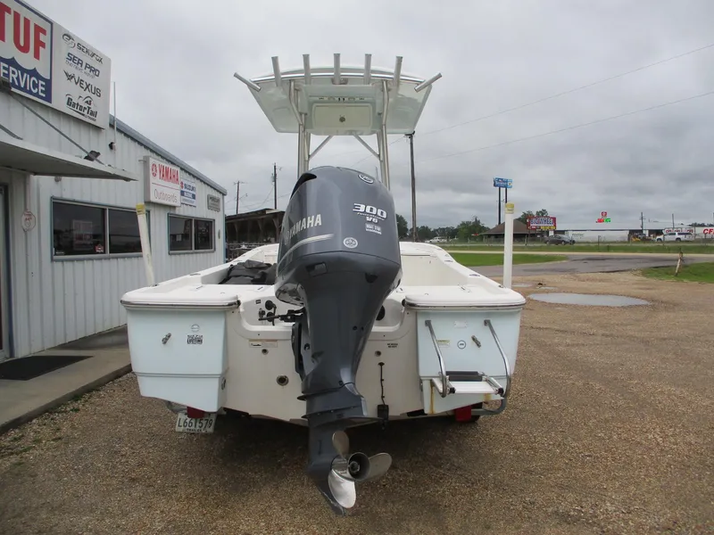 Slide: The Image of 2013 Sea Fox 240 Viper boat with Yamaha 300 HP engine, parked outside a service shop. - 2