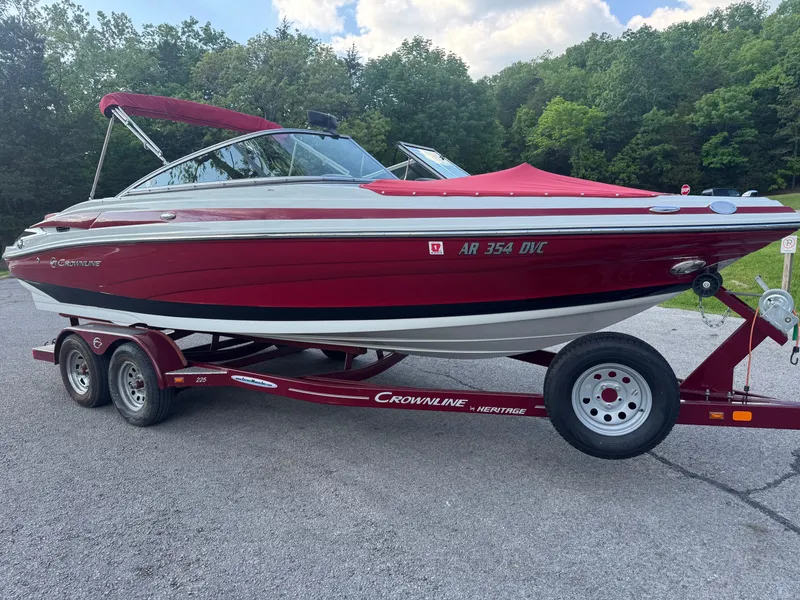 Slide: The Image of 2018 Crownline 225SS boat on trailer, red and white, parked outdoors. - 13