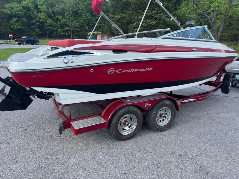 Slide: The Image of 2018 Crownline 225SS boat on trailer, red and white design, parked outdoors. - 14