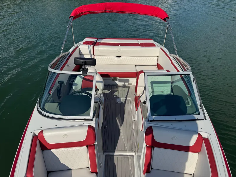 Slide: The Image of 2018 Crownline 225SS boat with red and white interior on calm water. - 5