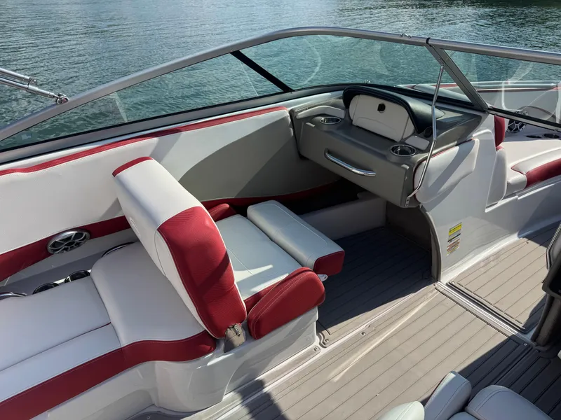 Slide: The Image of 2018 Crownline 225SS boat interior with red and white seating, on calm water. - 7