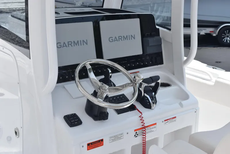 Slide: The Image of 2025 Sea Hunt Ultra 275 SE boat dashboard with dual Garmin displays and steering wheel. - 11