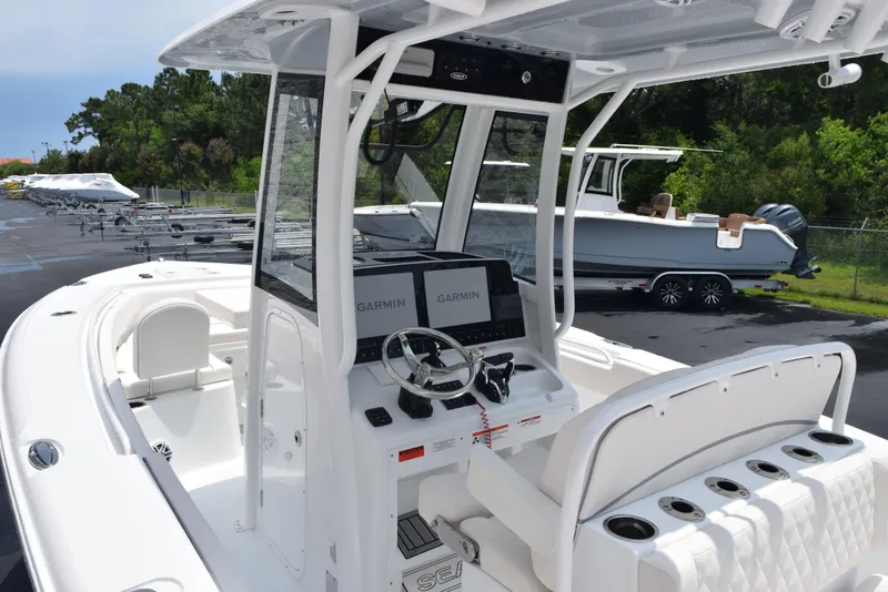Slide: The Image of 2025 Sea Hunt Ultra 275 SE boat with modern helm and seating, docked outdoors. - 7