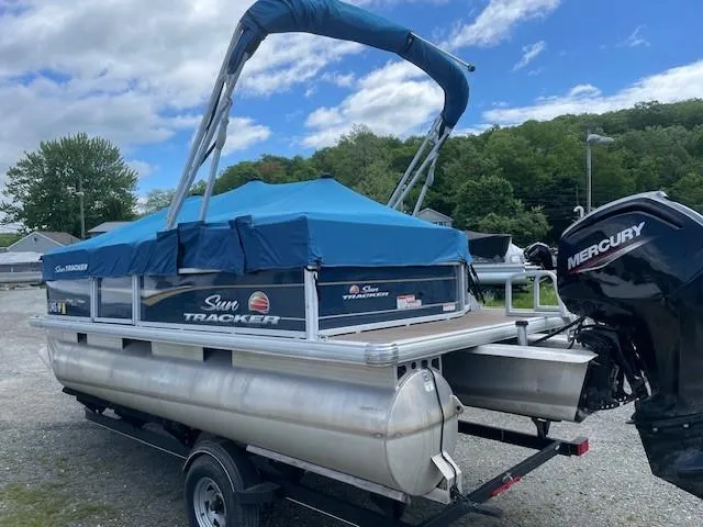 Slide: The Image of 2020 Sun Tracker Party Barge 18 DLX pontoon boat with blue canopy on trailer. - 3