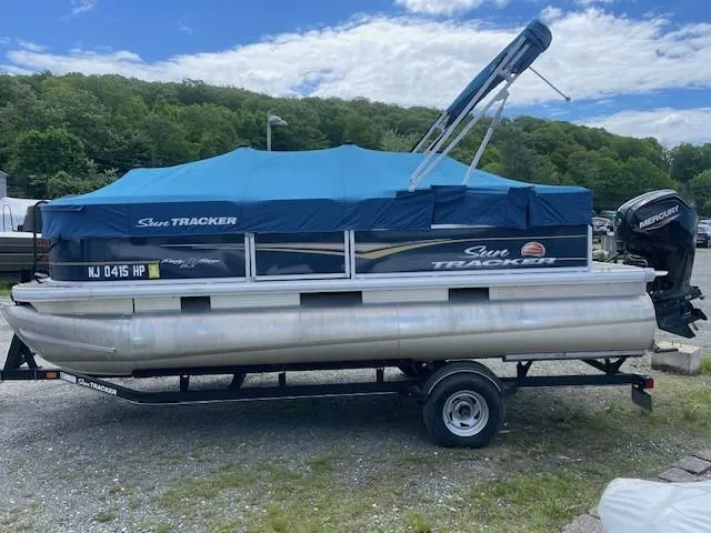 Slide: The Image of 2020 Sun Tracker Party Barge 18 DLX pontoon boat with blue cover on trailer. - 4