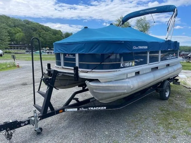 Slide: The Image of 2020 Sun Tracker Party Barge 18 DLX pontoon boat on trailer, covered and parked outdoors. - 5