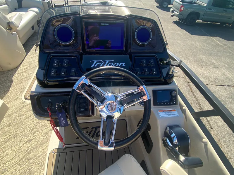 Slide: The Image of 2023 JC Sporttoon 26TT boat dashboard with steering wheel and control panel. - 17