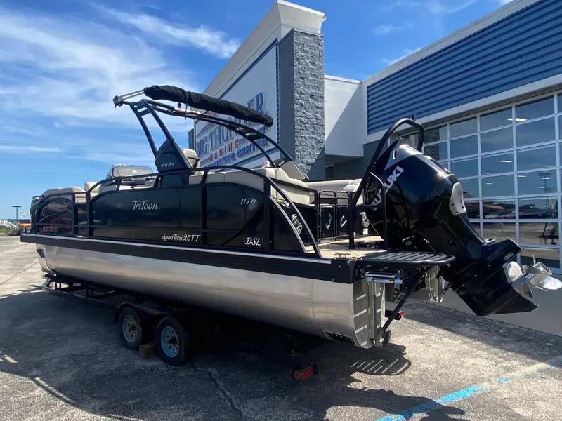 Slide: The Image of 2023 JC Sporttoon 26TT pontoon boat on trailer outside dealership. - 2