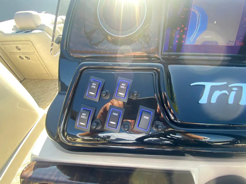 Slide: The Image of Control panel of 2023 JC Sporttoon 26TT boat with switches and sunlight reflection. - 20