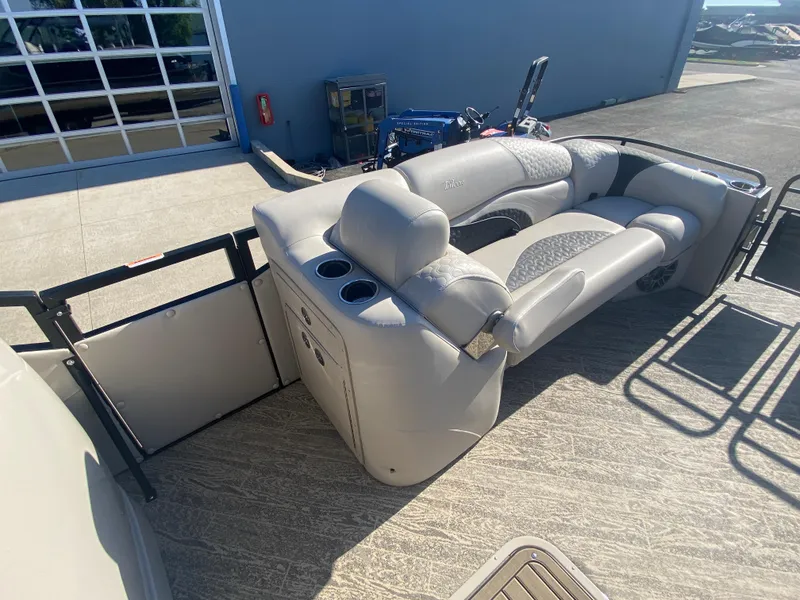 Slide: The Image of 2023 JC Sporttoon 26TT pontoon boat with plush seating and cup holders, docked outdoors. - 24