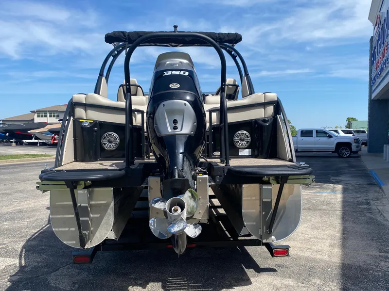 Slide: The Image of 2023 JC Sporttoon 26TT pontoon boat with powerful outboard motor, parked on pavement. - 3