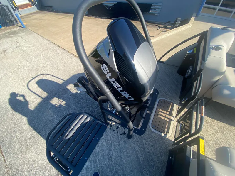 Slide: The Image of 2023 JC Sporttoon 26TT boat with Suzuki outboard motor, docked on concrete surface. - 34