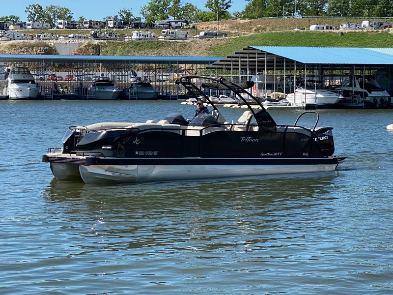Slide: The Image of 2023 JC Sporttoon 26TT pontoon boat on a sunny lake near a marina. - 36
