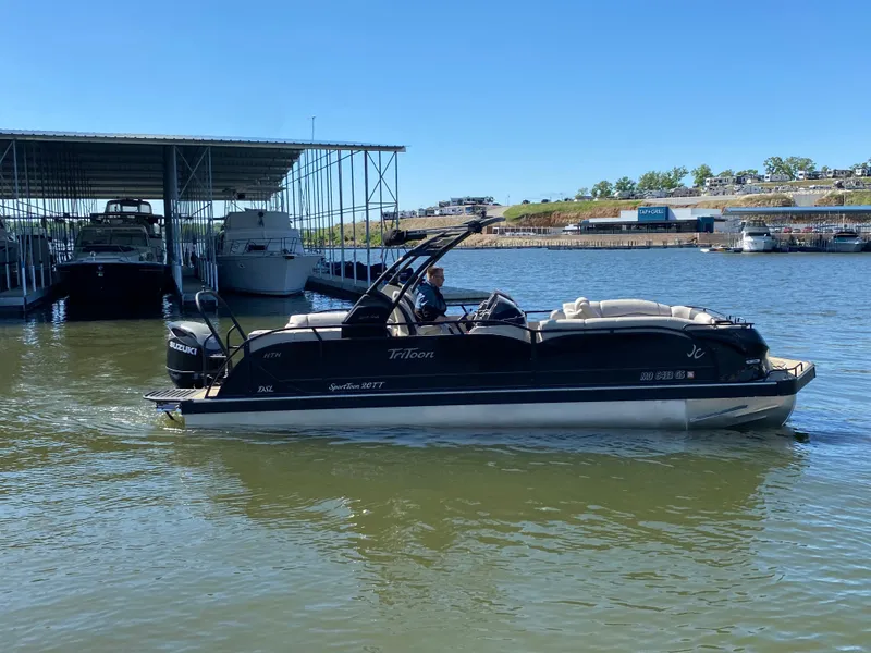 Slide: The Image of 2023 JC Sporttoon 26TT pontoon boat on a sunny lake near a marina. - 39