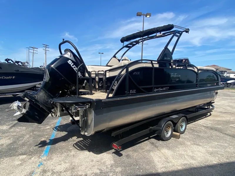 Slide: The Image of 2023 JC Sporttoon 26TT pontoon boat on trailer, featuring a powerful Suzuki outboard motor. - 4