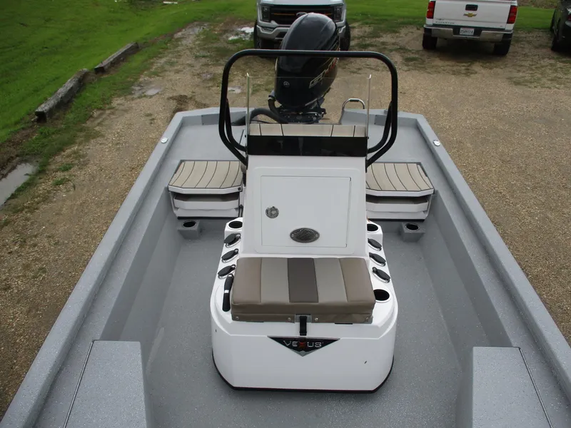 Slide: The Image of 2025 Vexus ACX2000 boat interior with seating and console, parked on gravel. - 12