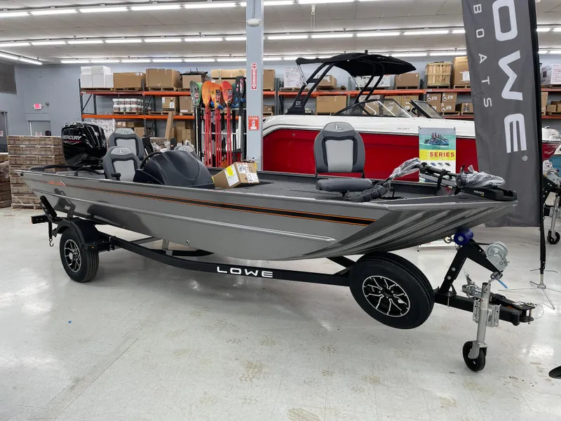 Slide: The Image of 2025 Lowe Legacy boat on display in showroom with trailer and accessories. - 1