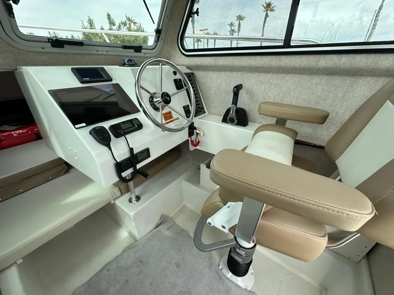 Slide: The Image of 2019 Parker 2120 Sport Cabin interior with steering wheel, control panel, and beige seating. - 5