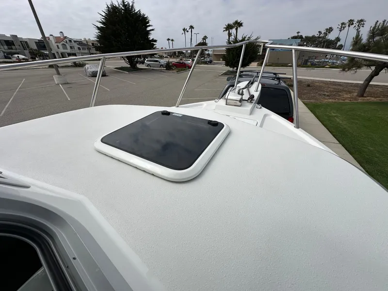 Slide: The Image of 2019 Parker 2120 Sport Cabin boat on trailer in parking lot, overcast sky. - 9