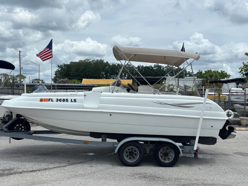 Slide: The Image of 2002 Monark Sunlounger 215 boat on trailer with canopy, parked outdoors. - 0