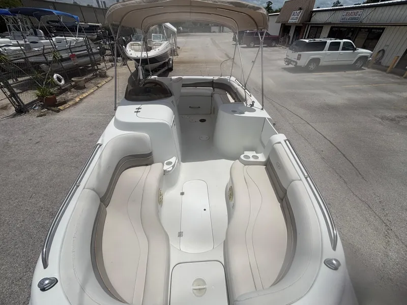 Slide: The Image of 2002 Monark Sunlounger 215 boat with spacious seating and canopy in a marina setting. - 11
