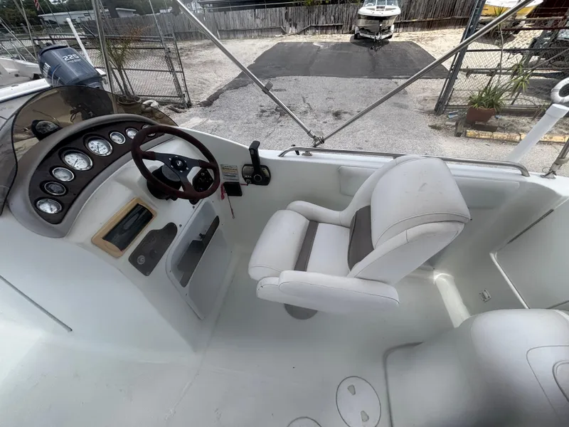 Slide: The Image of 2002 Monark Sunlounger 215 boat cockpit with steering wheel and white captain's chair. - 18