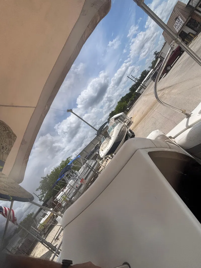 Slide: The Image of 2002 Monark Sunlounger 215 boat docked under a cloudy sky. - 25