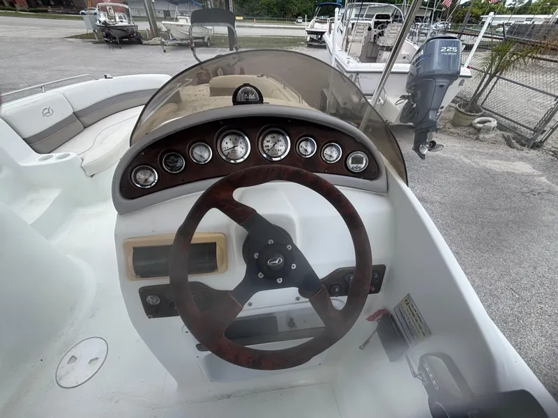 Slide: The Image of Steering console of a 2002 Monark Sunlounger 215 boat with gauges and wooden wheel. - 27