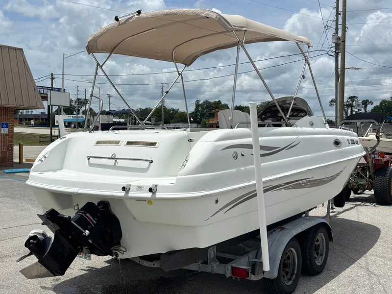 Slide: The Image of 2002 Monark Sunlounger 215 boat on trailer, featuring a canopy and outboard motor. - 4