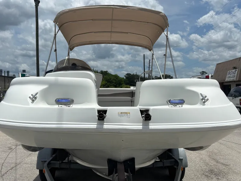 Slide: The Image of 2002 Monark Sunlounger 215 boat with canopy, parked on trailer under cloudy sky. - 7