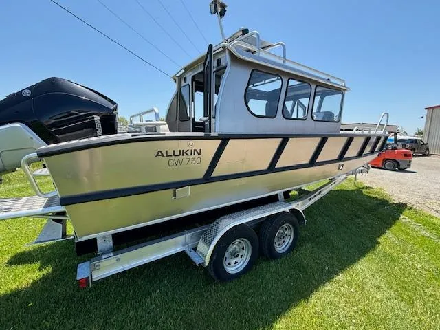 Slide: The Image of 2024 Alukin CW750 boat on trailer, parked on grass under clear blue sky. - 13