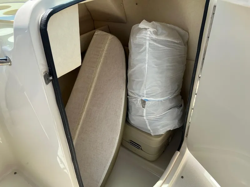 Slide: The Image of Storage compartment in a 2005 Sea Ray 220 Sundeck boat with cushions and wrapped items. - 14