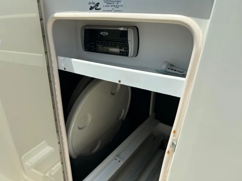 Slide: The Image of 2005 Sea Ray 220 Sundeck storage compartment with stereo system. - 16