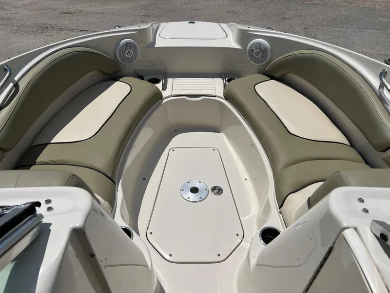 Slide: The Image of 2005 Sea Ray 220 Sundeck boat interior with cushioned seating and speakers. - 2