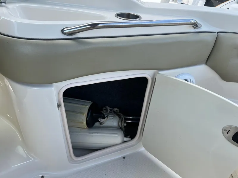 Slide: The Image of Open storage compartment on 2005 Sea Ray 220 Sundeck boat, showing interior equipment. - 22