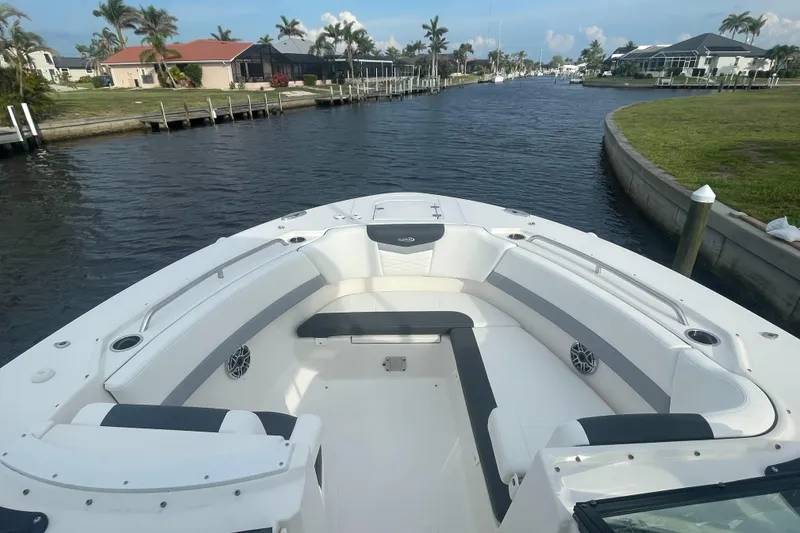 Slide: The Image of 2023 Robalo R317 Dual Console boat on a scenic waterway with palm trees. - 10